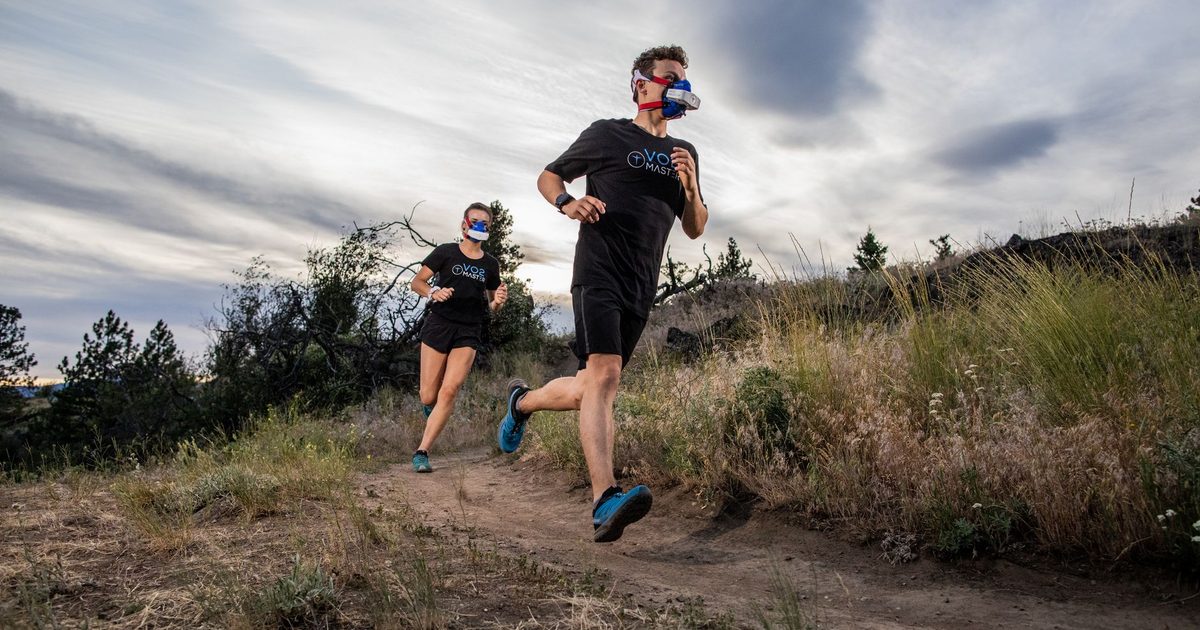 Athletes in VO2 masks running on a trail, showcasing outdoor athletic performance.