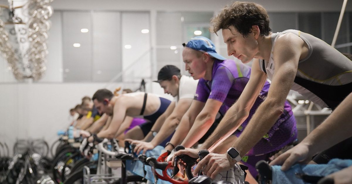 Athletes engaged in a high-intensity indoor cycling session, enhancing fitness and endurance.