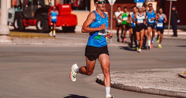 Dynamic image of a male athlete leading a marathon on a sunny day, showcasing determination and endurance.