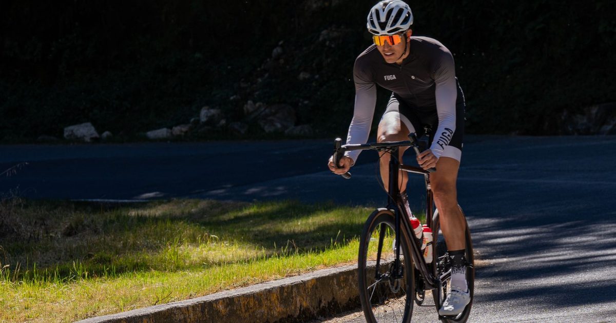 Professional cyclist riding on a sunny mountain road, embodying athletic determination.