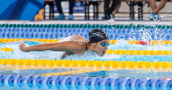 A swimmer in a race swimming the butterfly stroke during a competitive event.