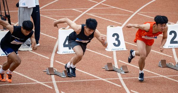 Young male sprinters launching off at the starting line, showcasing athletic determination on the track.