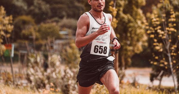 Athlete participating in an outdoor marathon with race number 658 during daytime.