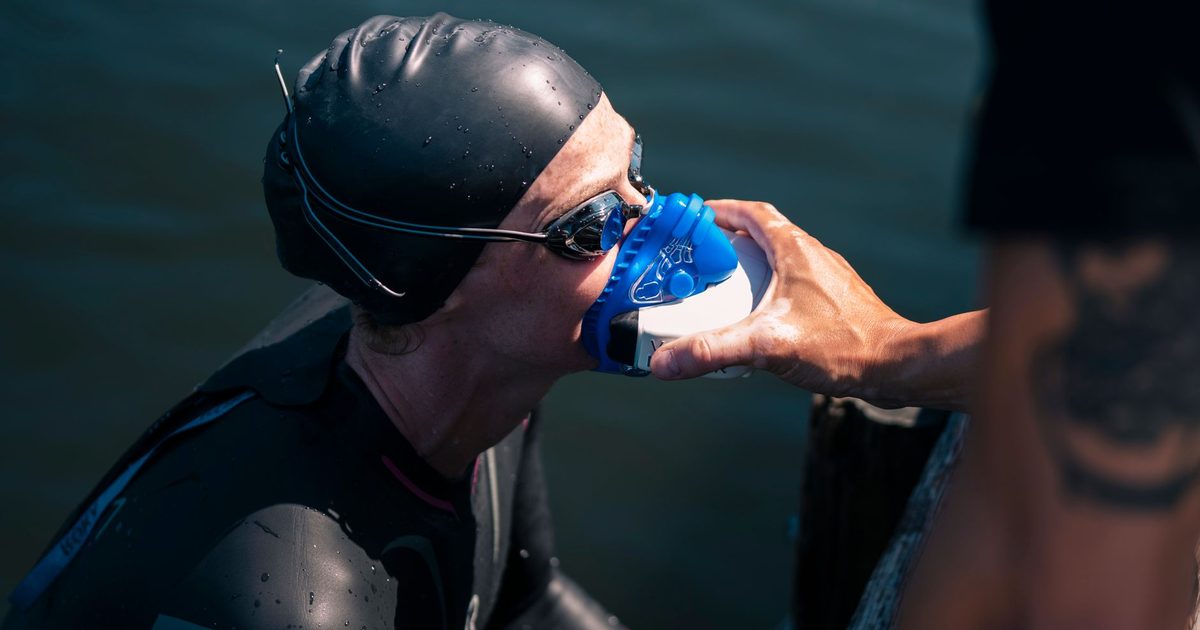 A swimmer uses a rescue mask for oxygen after completing an outdoor swim.