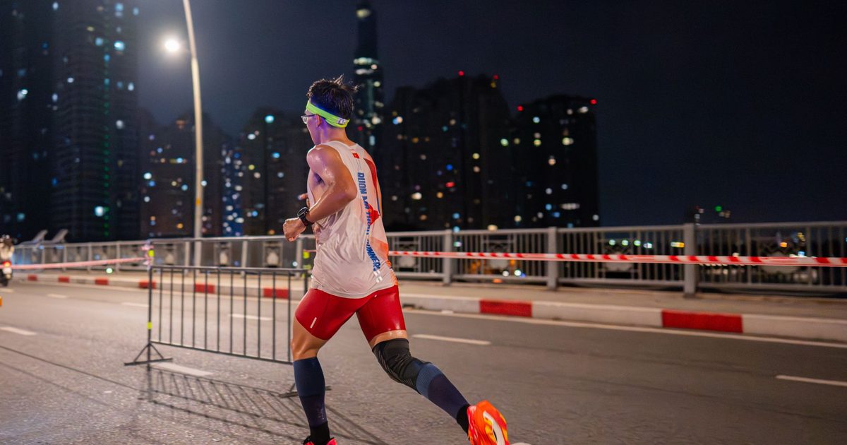 Runner in bright urban environment participating in night marathon.